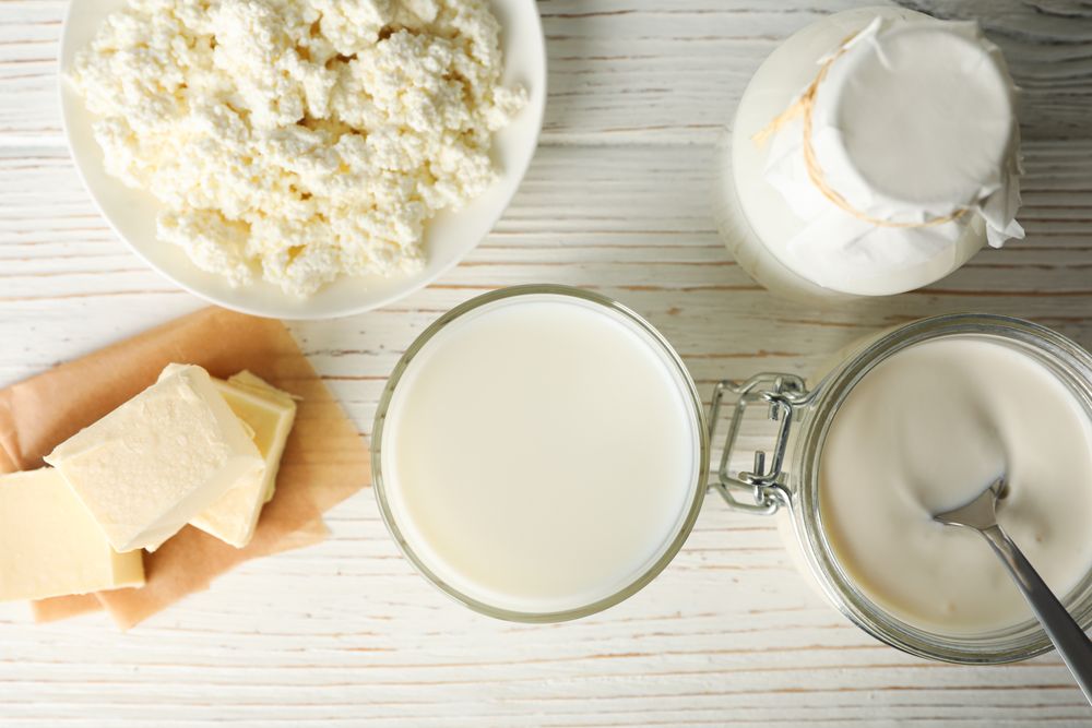 Different dairy products on wooden background, top view