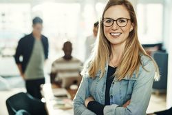 Portrait of happy woman in office wearing jean jacket