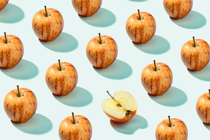 Half apple in row with whole apples