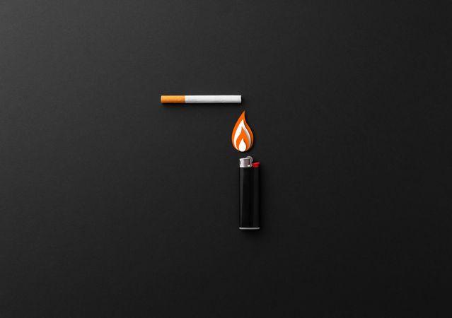 One lighter and one cigarette on dark background