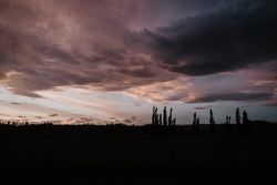 Evening cloudy sky above dark field