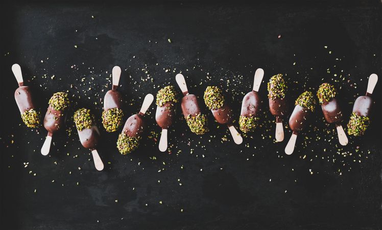 Ice cream chocolate pistachio popsicles, dark background, top view