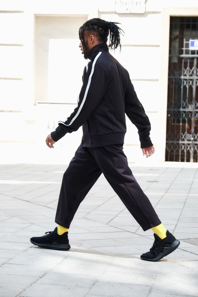 Black braided male walking down street