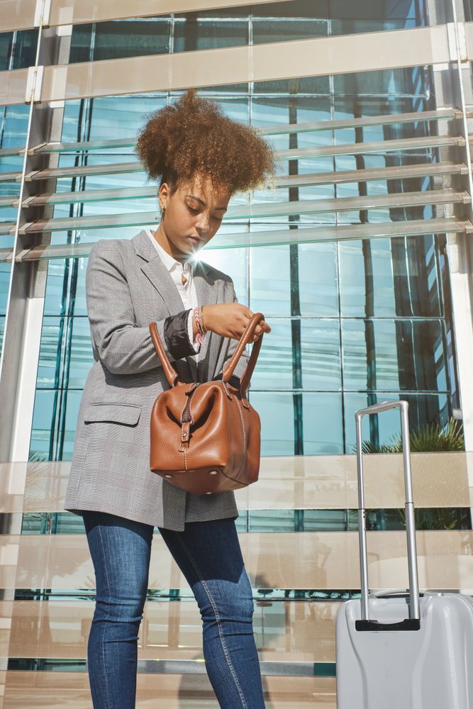 Concentrated Black woman with suitcase in street