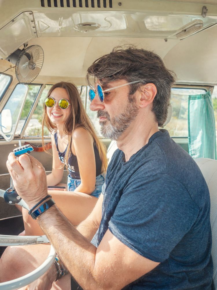 Man and woman watching and discussing blue thing in car
