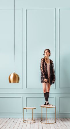 Ballerina posing on a turquoise background.