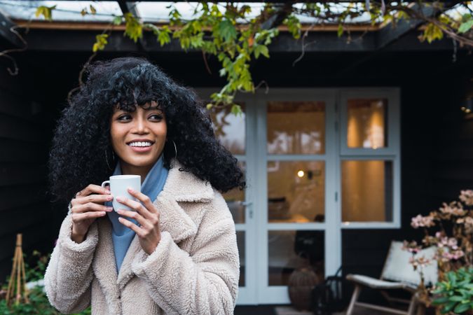 Smiling Black woman with cup of coffee