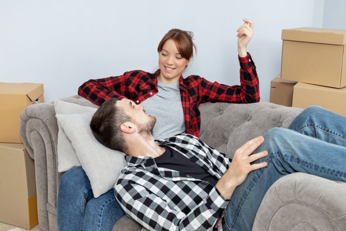 Moving concept, couple man and woman with boxes in apartment.