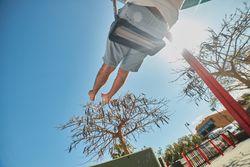 Man swinging on playground in sunlight
