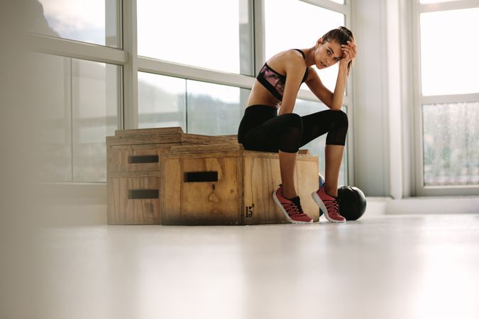 Exhausted fitness woman resting at gym