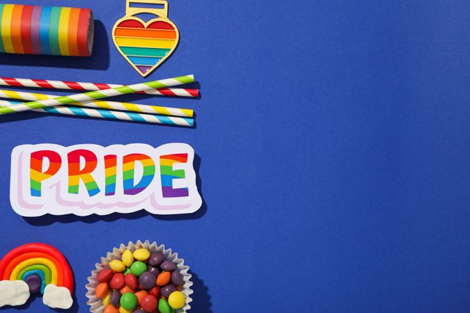Pride parade concept, festive colorful symbols on blue background.