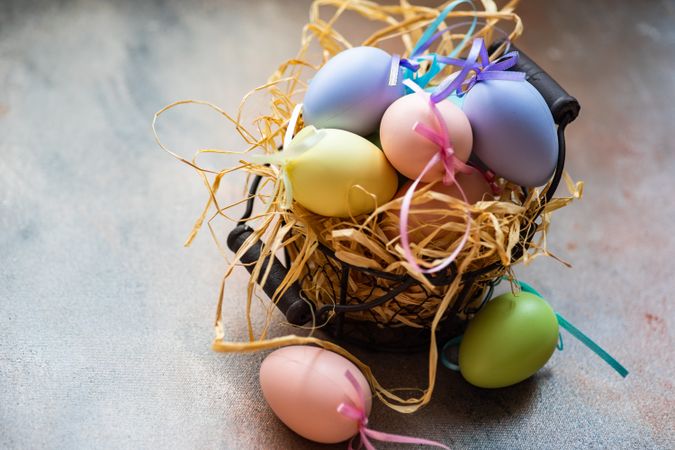 Decorative Easter eggs in straw on table with copy space
