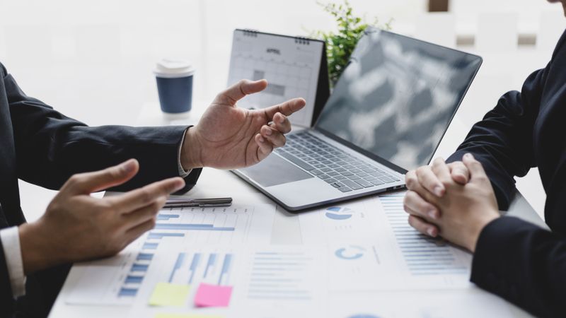 Business People Looking at Graphs in Meeting