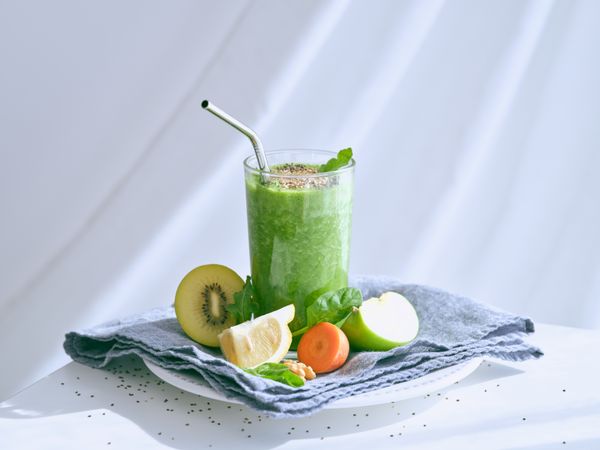 Smoothie with seeds on towel with fruits