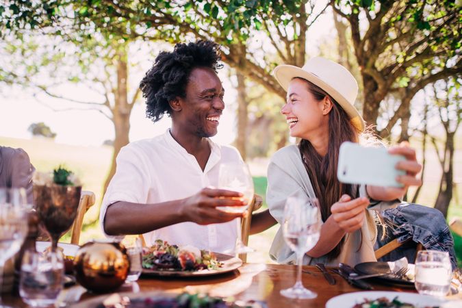 A man and woman take a selfie at an elegant outdoor table setting