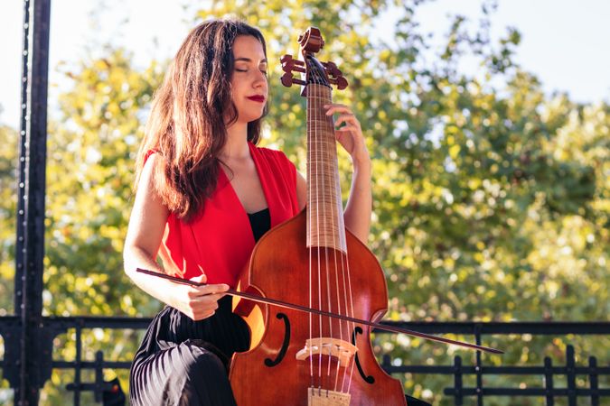 Woman musician playing cello outdoors