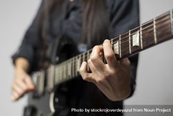 Close up of a female guitarist's hands while playing chords on the electric guitar 0Pjjd7