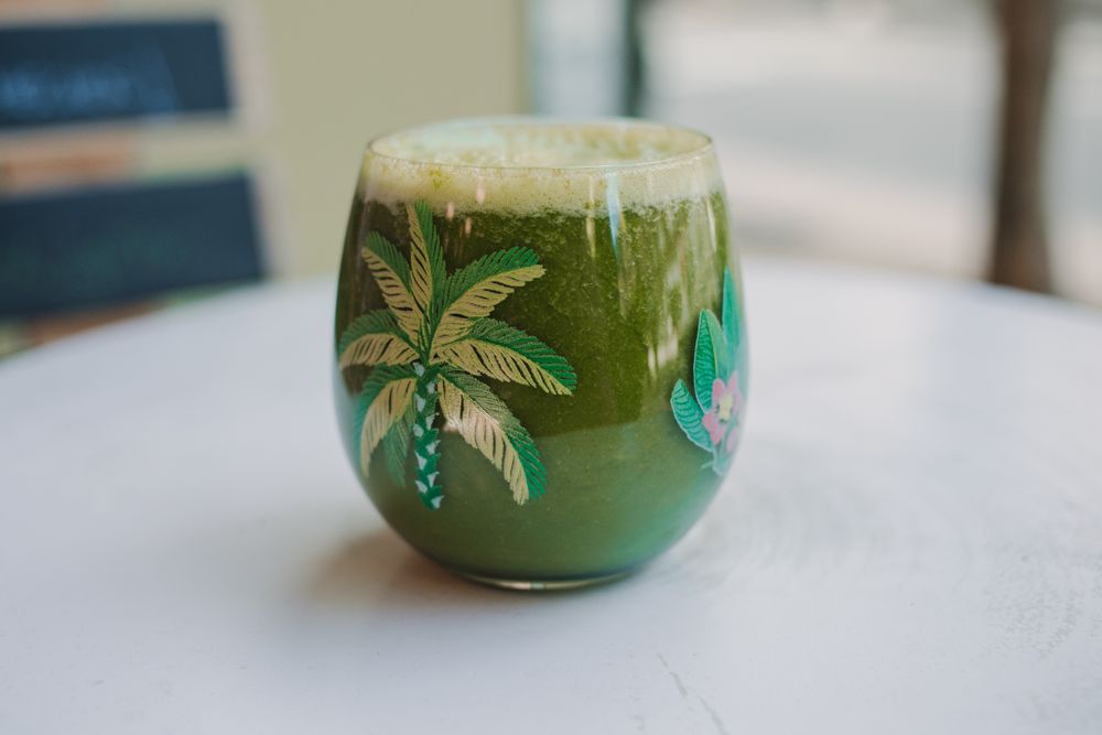 Delicious green smoothie with frothy in glass