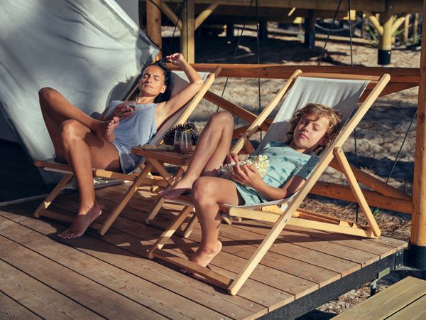 Mother with son resting on deckchairs