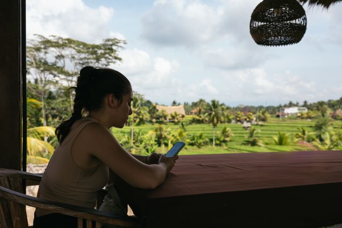 Woman using Mobile Phone with a beautiful landscape