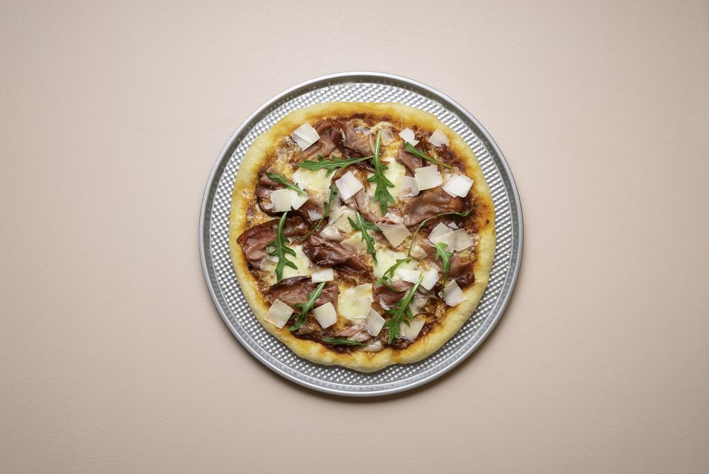 Whole ham pizza on pizza tray