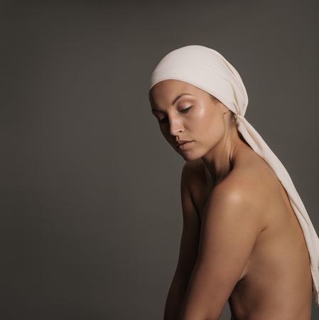 Woman with a scarf wrapped on her head on studio, copy space