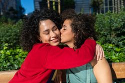 Happy female couple hugging in city park