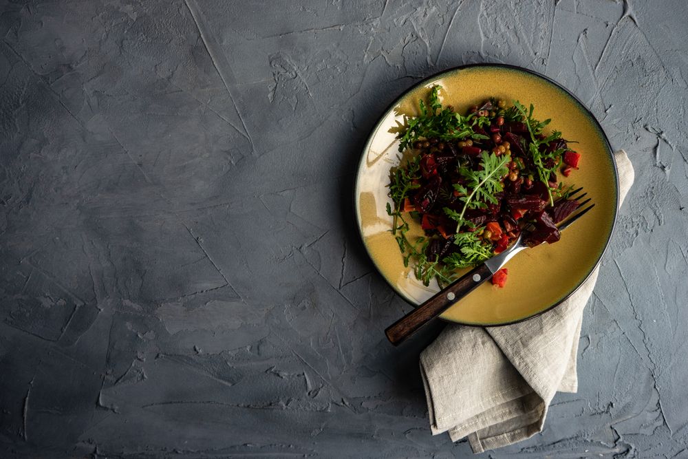 Top view of yellow plate of beet salad served with copy space