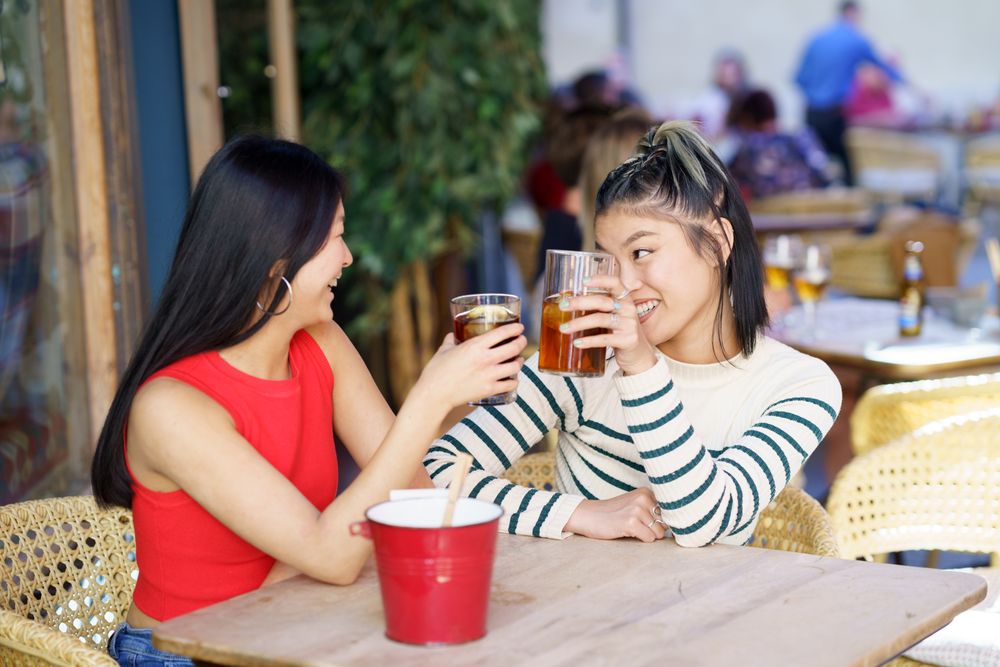 Two women sitting in restaurant patio enjoying their drinks