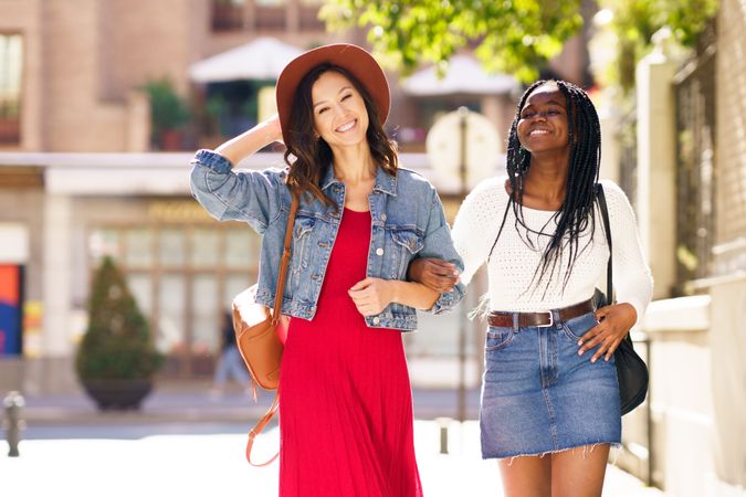 Female friends strolling down a sunny street