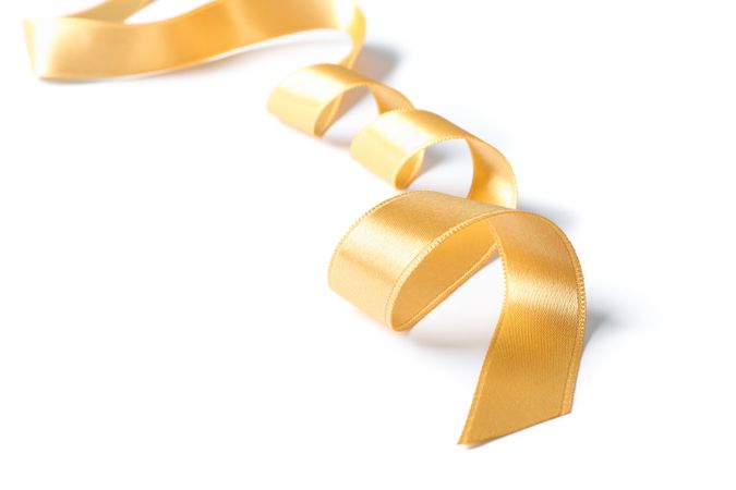 Gold ribbon isolated on plain background. Gift concept
