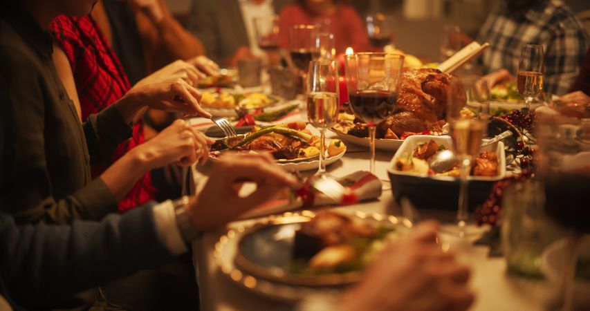 Portrait of a Diverse Group of Relatives and Friends Sitting Together Behind a Dining Table with Tasty Meals and Festive Decorations.