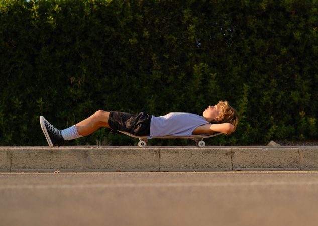 Carefree skater lying on skateboard in city