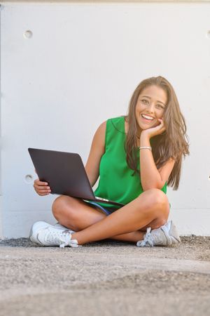 Female browsing laptop on street