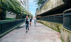 Women runners training on runway with palm trees