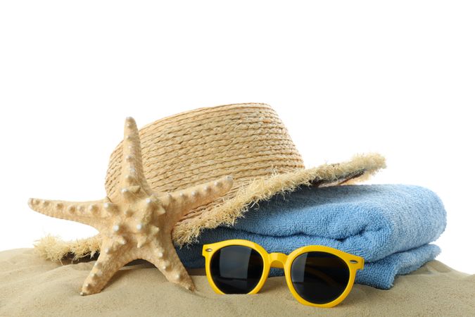 Summer vacation accessories in clear sea sand isolated on blank background. Summer vacation