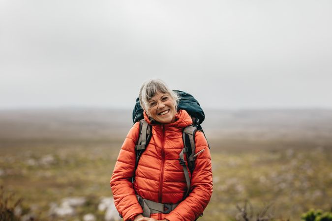 Smiling woman on a hiking trip on a hill on a winter day