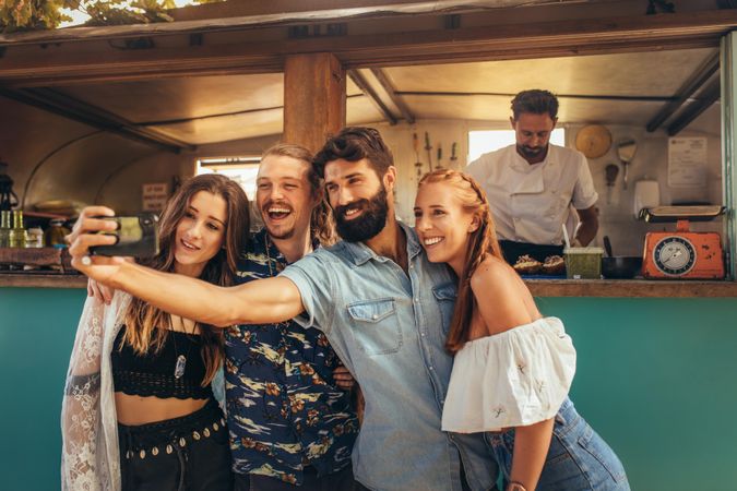 Happy millennial friends taking selfie