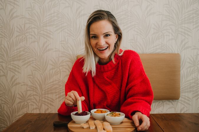 Woman smiling eating assorted food at table