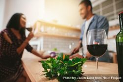 Man and woman talking in the kitchen with glass of wine in focus 5kPpG4