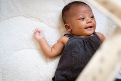 Cute baby girl smiling and lying on her back