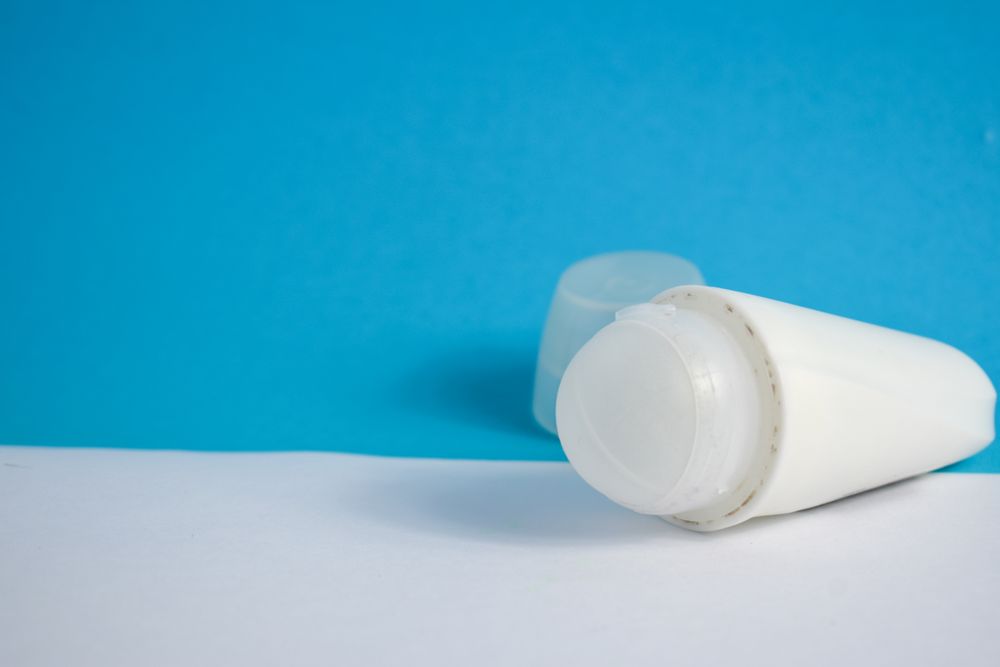 Roller cosmetic bottle lying on blue background