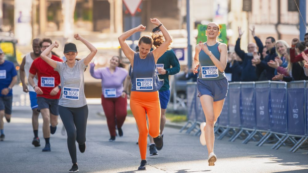 Women Supporting Women: Portrait of Happy Female Runners Participating in a Marathon.