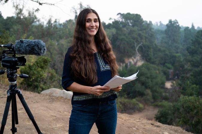Female director smiling confidently with script in hand