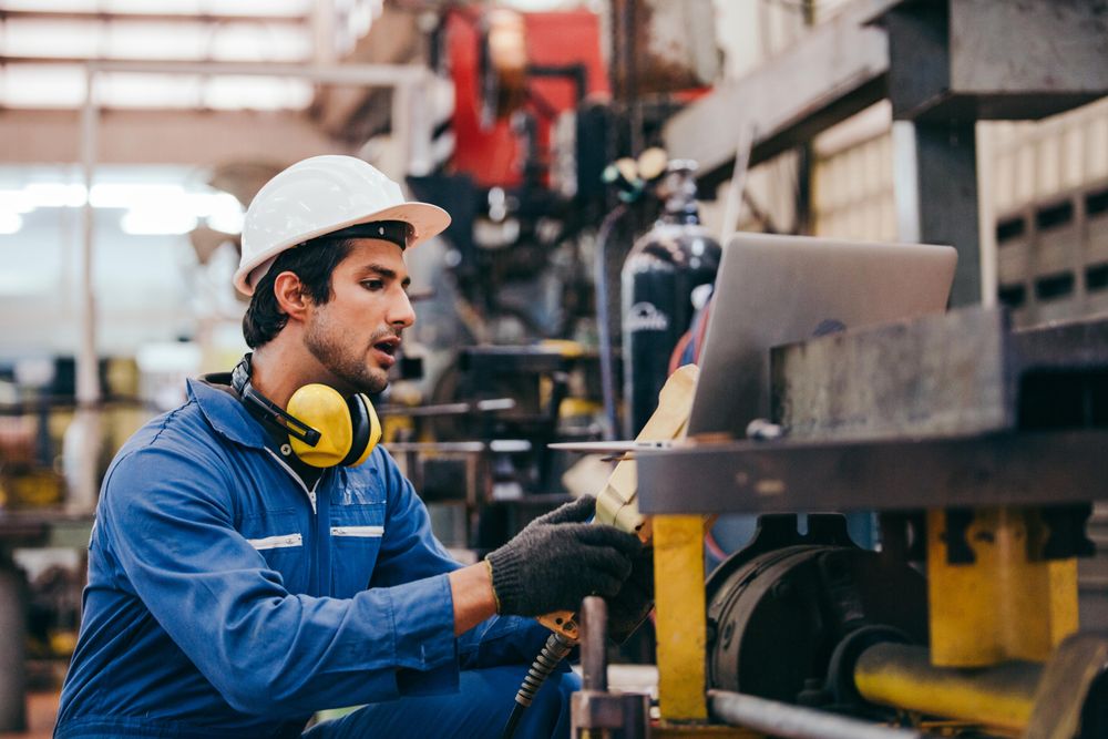 Male industrial engineer or technician worker in hard helmet and uniform