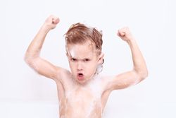 Boy showing biceps in bathroom