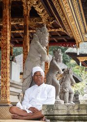 Bali, Indonesia - August, 15 2015: Indonesian man sitting near Hindu temple