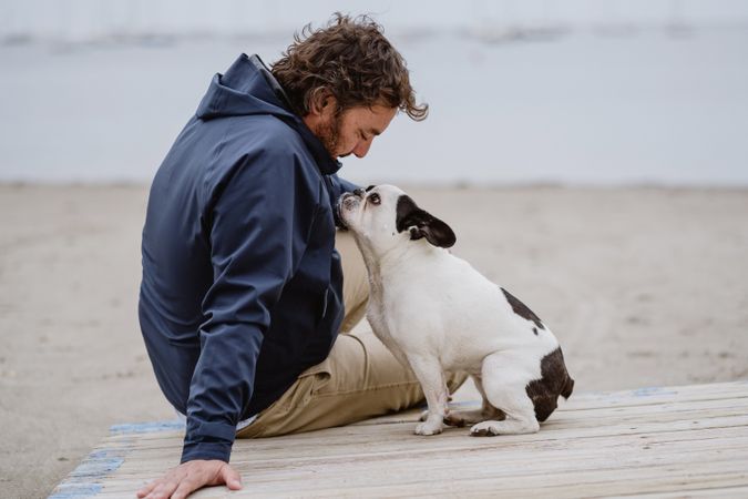 Man and dog resting on beach together