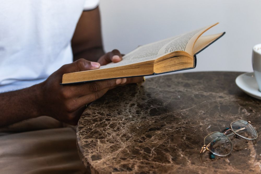 Black male reading book in cafeteria