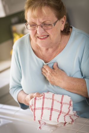 Older Adult Woman At Sink With Chest Pains